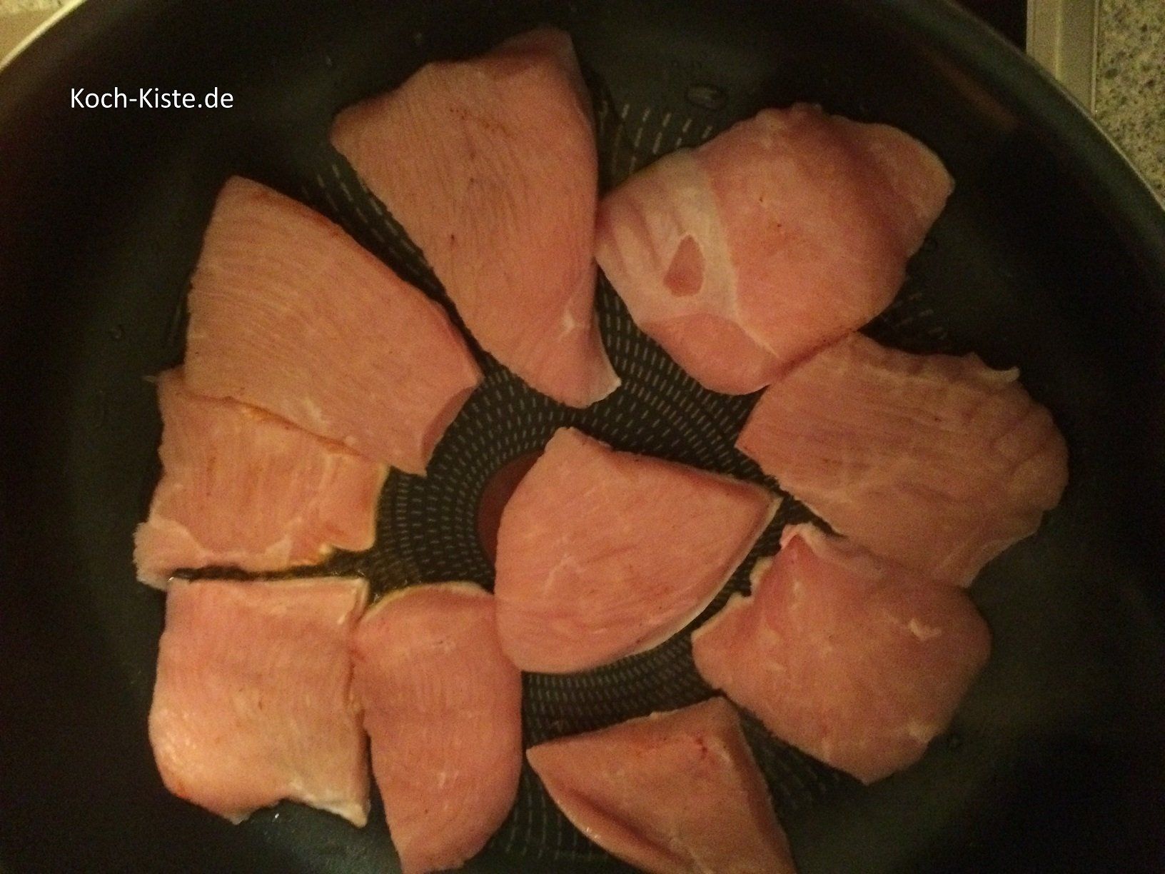 Schnitzel mit der gewürzten Seite nach unten in die Pfanne geben