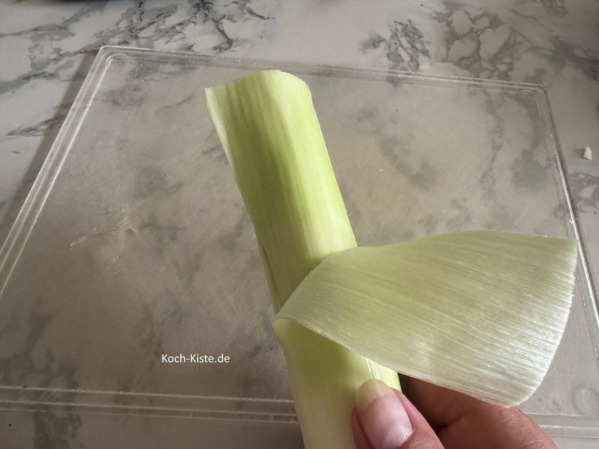 als nächstes schneide die Porreestange oben etwas ein und ziehe dann die äußere Schicht nach unten hin ab