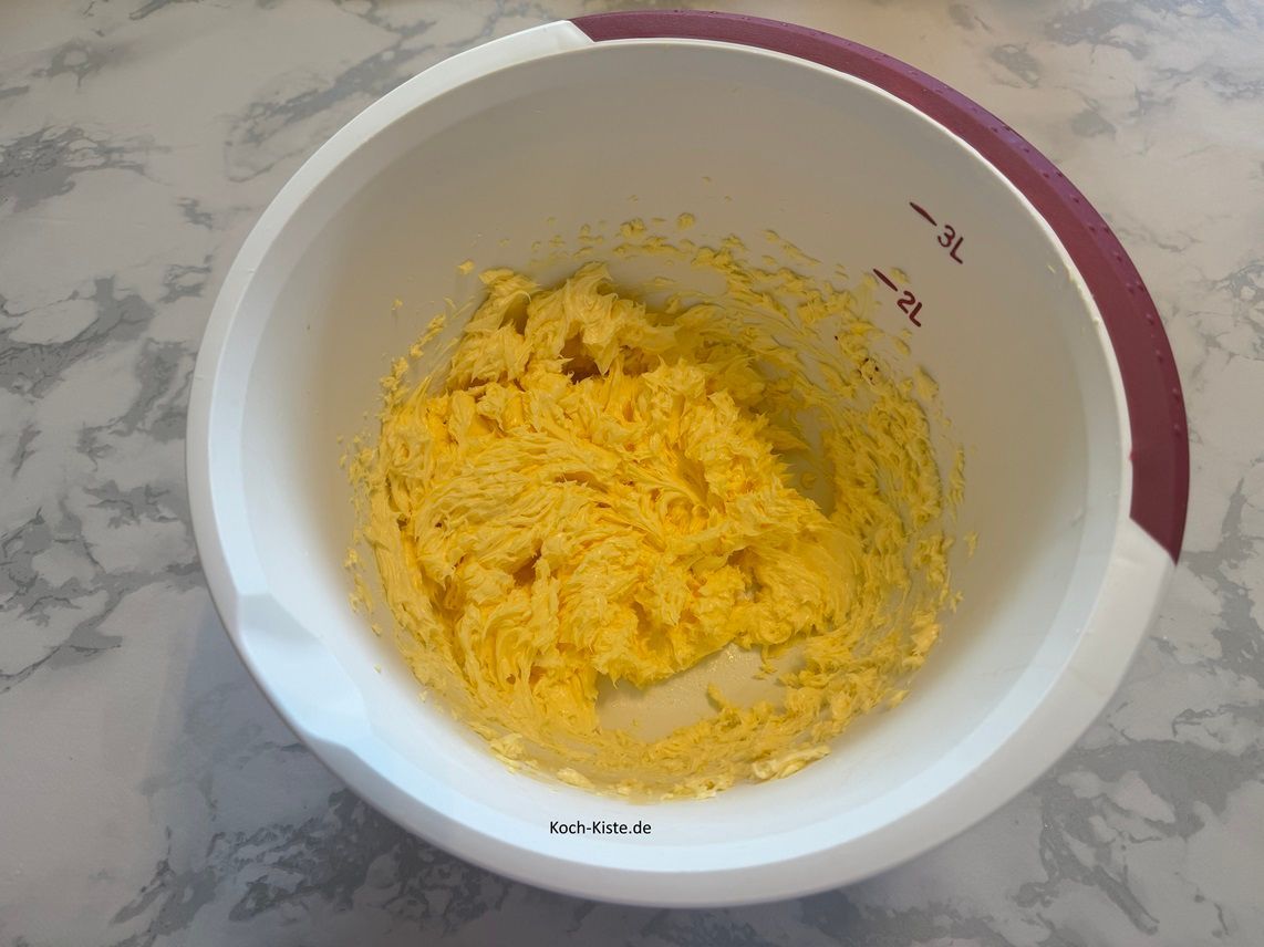 gebe zu den Eigelben die 250 g weiche Butter und schlage sie mit dem Handrührgerät zu einer cremigen Masse.