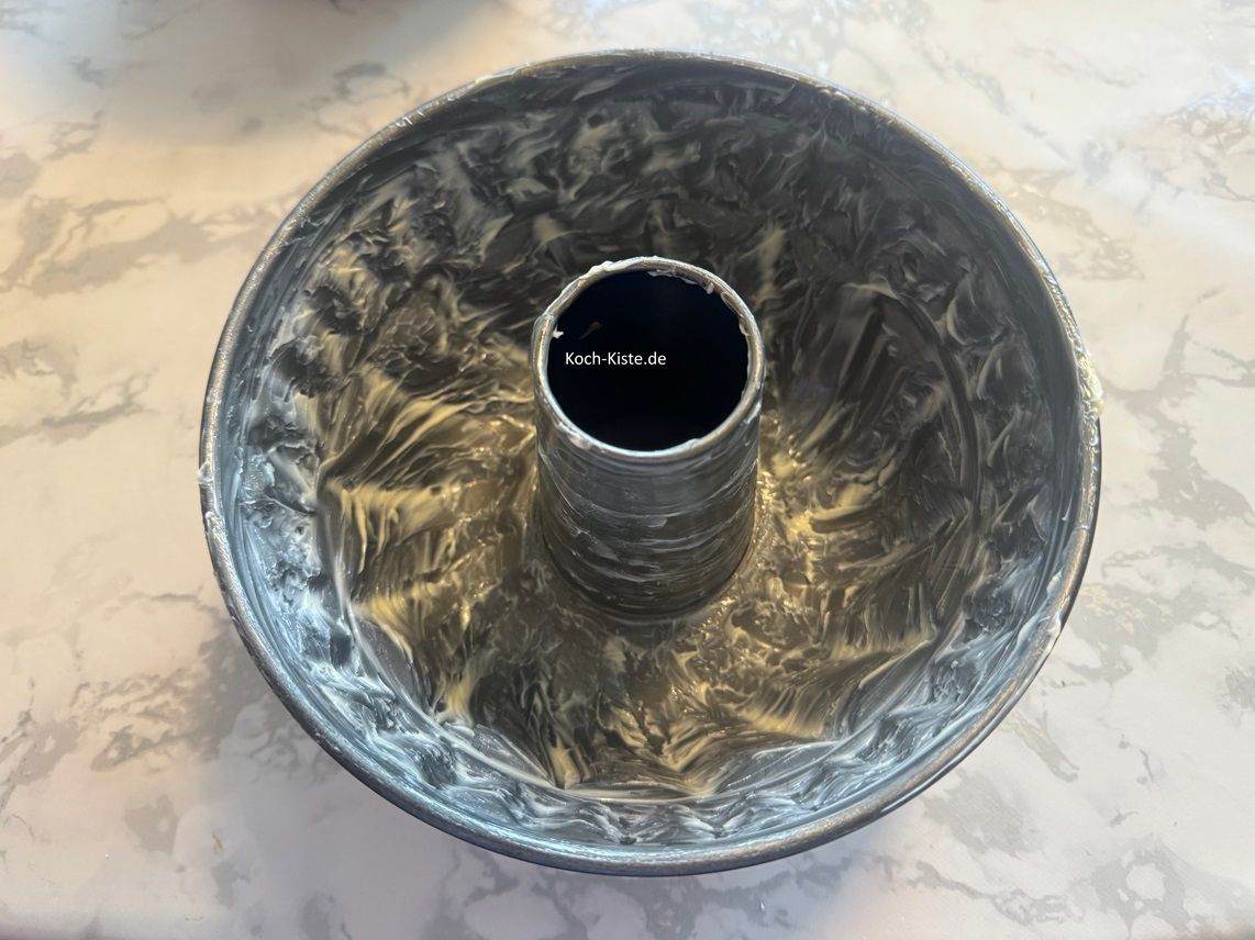 als nächstes nehme Dir mit dem Stück Backpapier etwas weiche Butter und fette die Pufferform ein