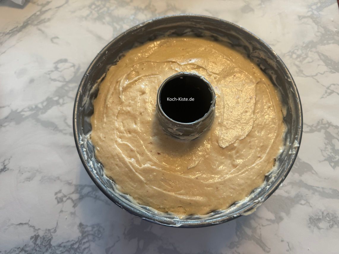 jetzt fülle den Teig mit dem Teiglöffel in die Pufferform und streiche ihn oben glatt. Schiebe die Pufferform auf die mittlere Schiene des Backofens und backe den Quark-Frucht Puffer 60 Minuten