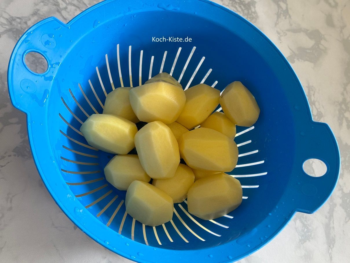 beginne damit 1 kg Kartoffeln zu schälen, in ein Sieb zu geben und unter kaltem, fließende Wasser abzuspülen