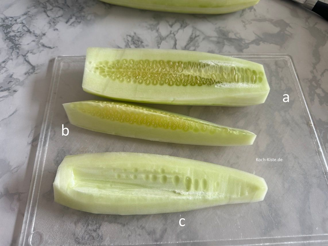 nun halbiere die Schmorgurke (a), schneide sie in Viertel (b) und schneide dann das Kerngehäuse heraus (c). Wiederhole die Schritte bei der 2 Schmorgurke.