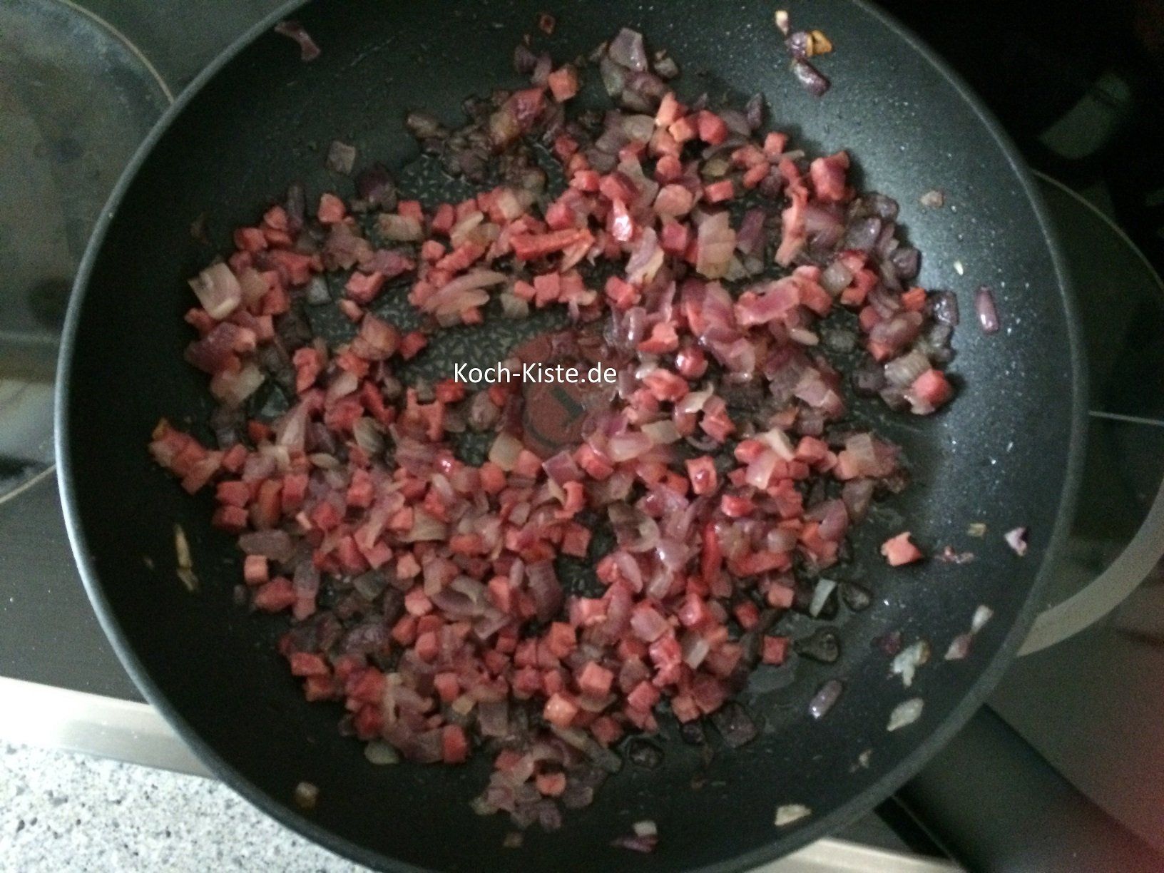 Zwiebeln und Schinkenwürfel in Butterschmalz anbraten