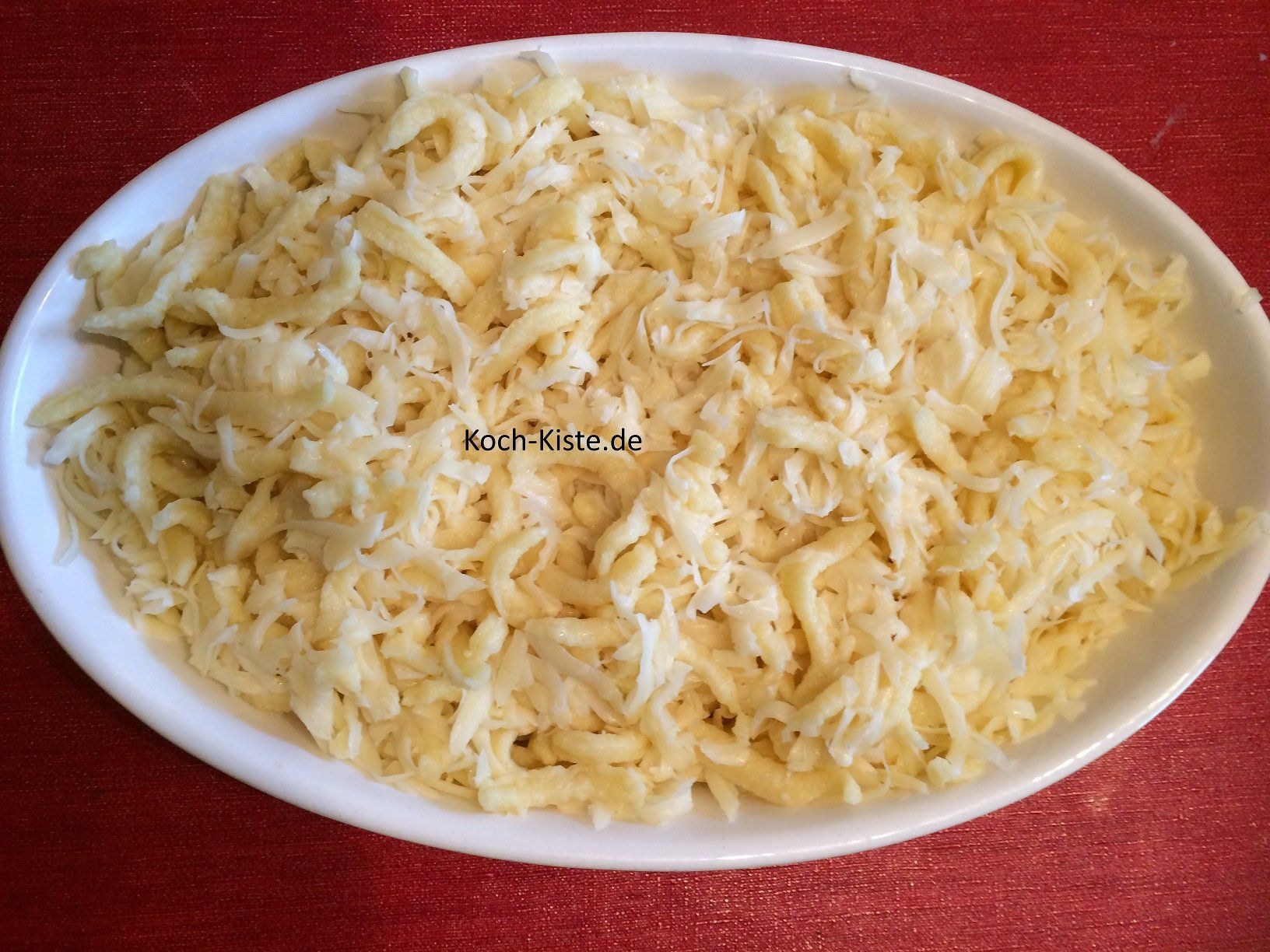 Käsespätzle und geriebenen Käse durchmengen