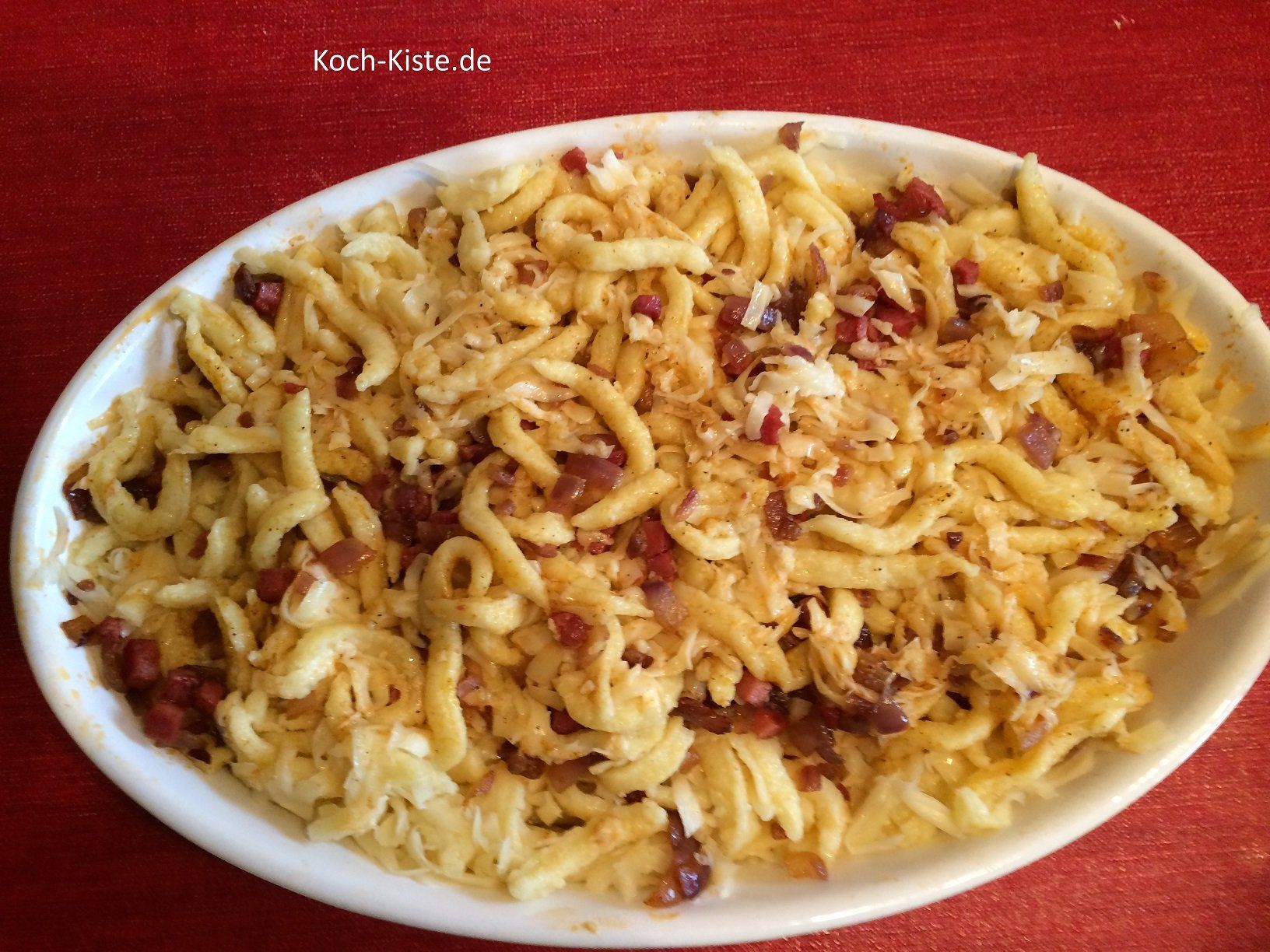 Zwiebel und Schinkenwürfel unter die Spätzle rühren