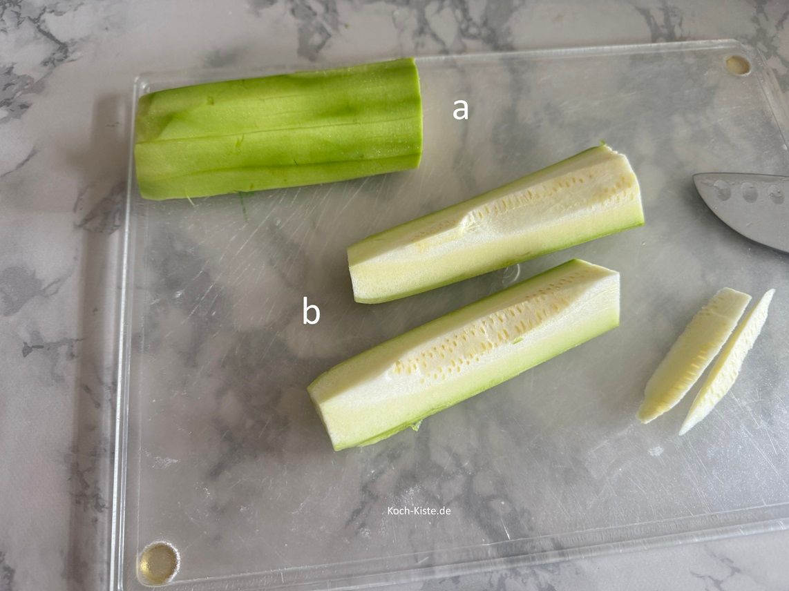 halbiere die Zucchini , dann viertel sie und schneide - nach Vorliebe - die Kerne heraus.