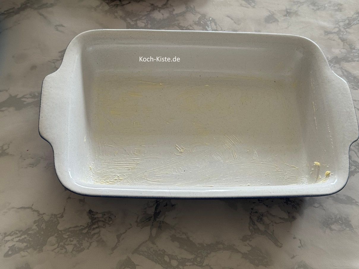 gebe einen guten Teelöffel weiche Butter in die Aufflaufform und verteile die Butter mit dem Silikopinsel