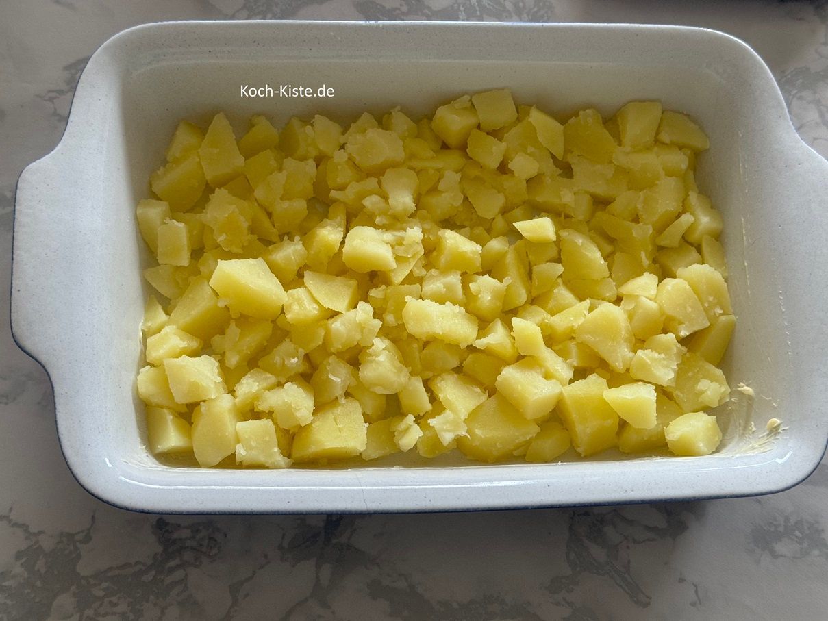 schütte die Kartoffelstücke in die Auflaufform und verteile sie gleichmäßig