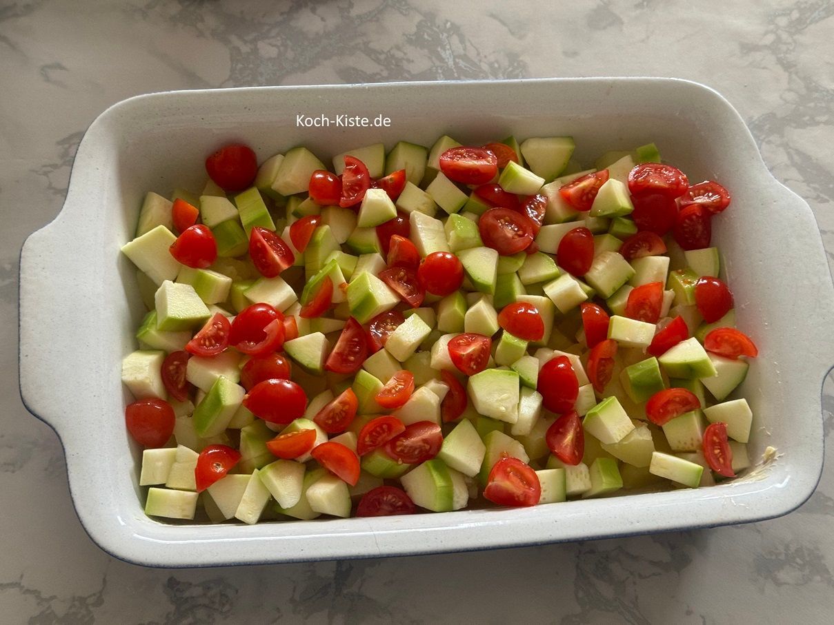 danach werden die Zucchinistücke und Tomatenstücke gleichmäßig oben auf verteilt