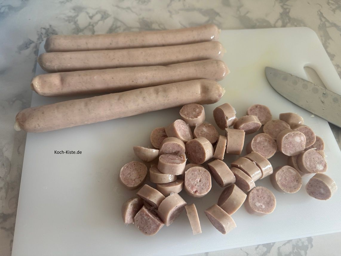 lege die Rostbratwürstchen auf das Schneidebrett und schneide sie in Scheiben