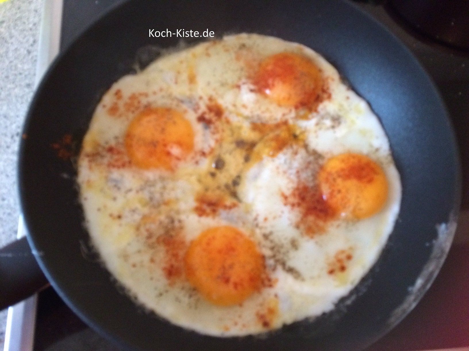 Eier in die Pfanne geben, würzen und mit dem Pfannenwender trennen