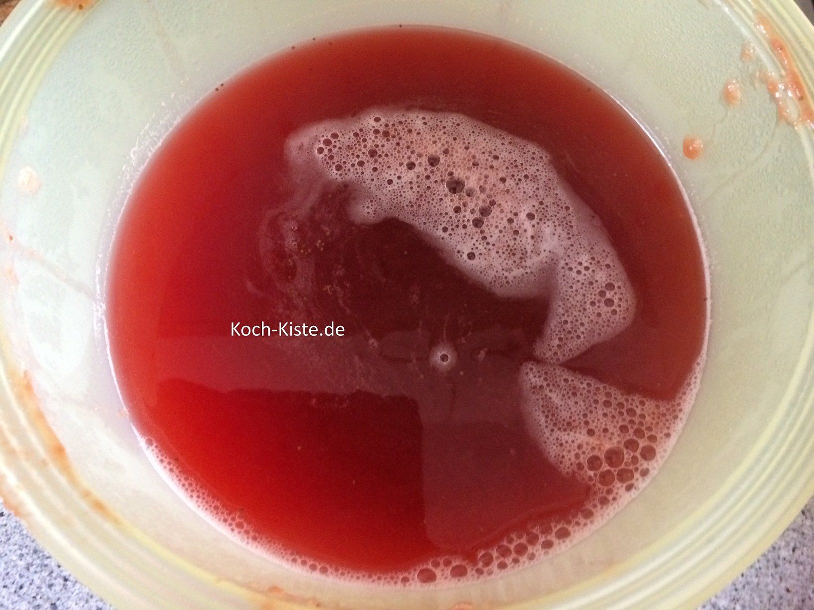 Erdbeeren in ein Haarsieb schütten und Saft auffangen