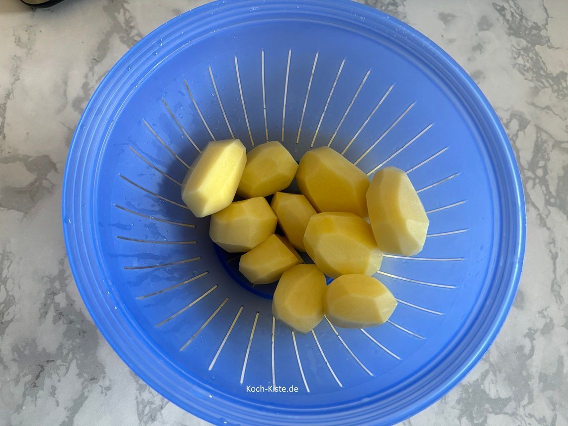 jetzt schäle die Kartoffeln und lege sie in ein Küchensieb. Dann spüle die Kartoffeln unter kaltem, fließendem Wasser ab und lasse sie kurz abtropfen.