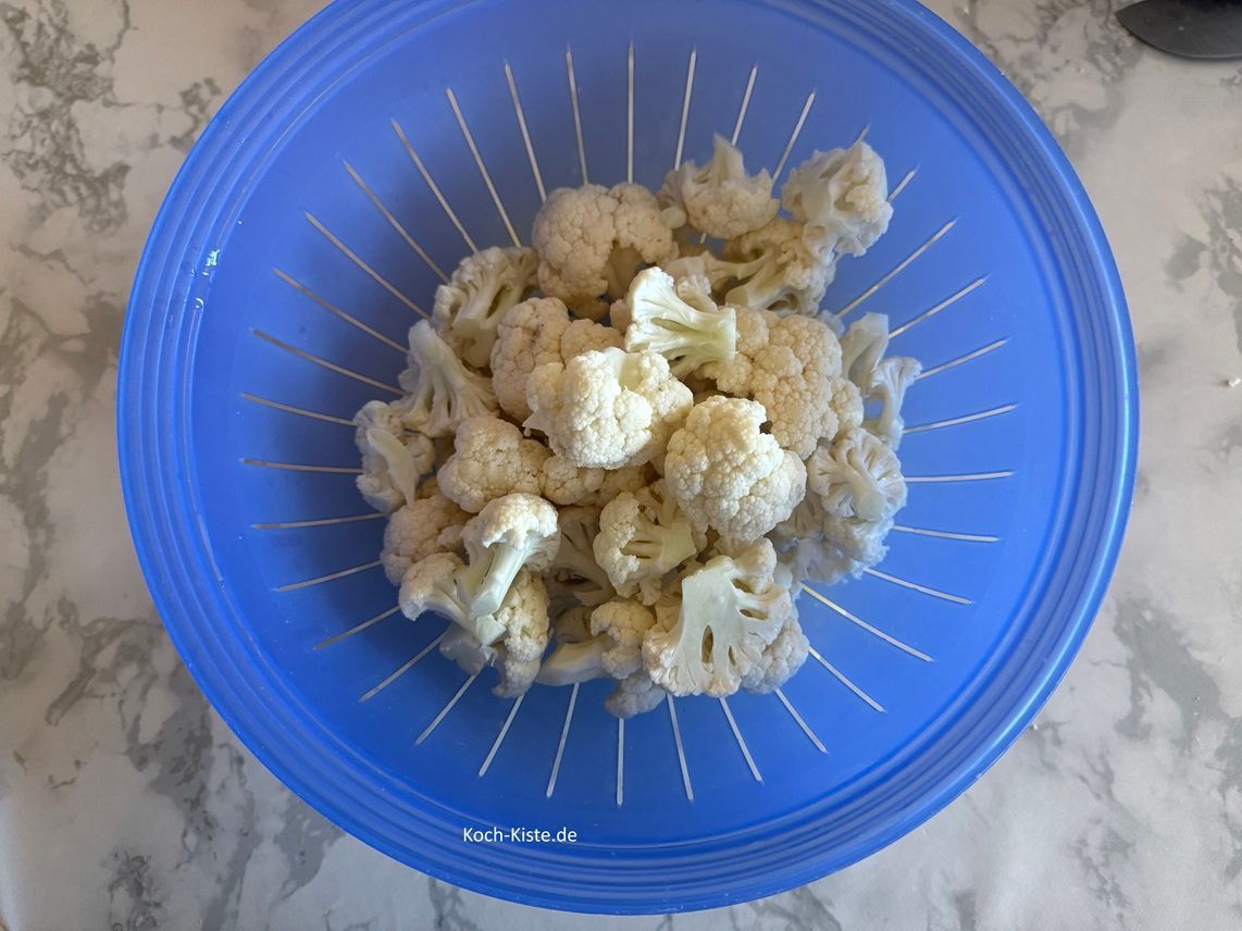 und gebe sie in ein Küchensieb. Spüle die Blumenkohlrößchen unter kaltem, fließendem Wasser ab