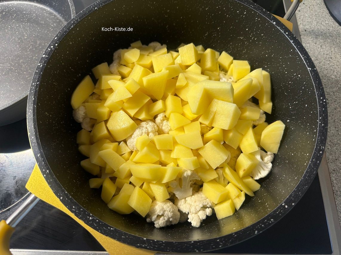 gebe die Kartoffelstücke mit in den Topf zum Blumenkohl. Gieße soviel Wasser in den Topf, das alles bedeckt ist und bringe alles zum Kochen.