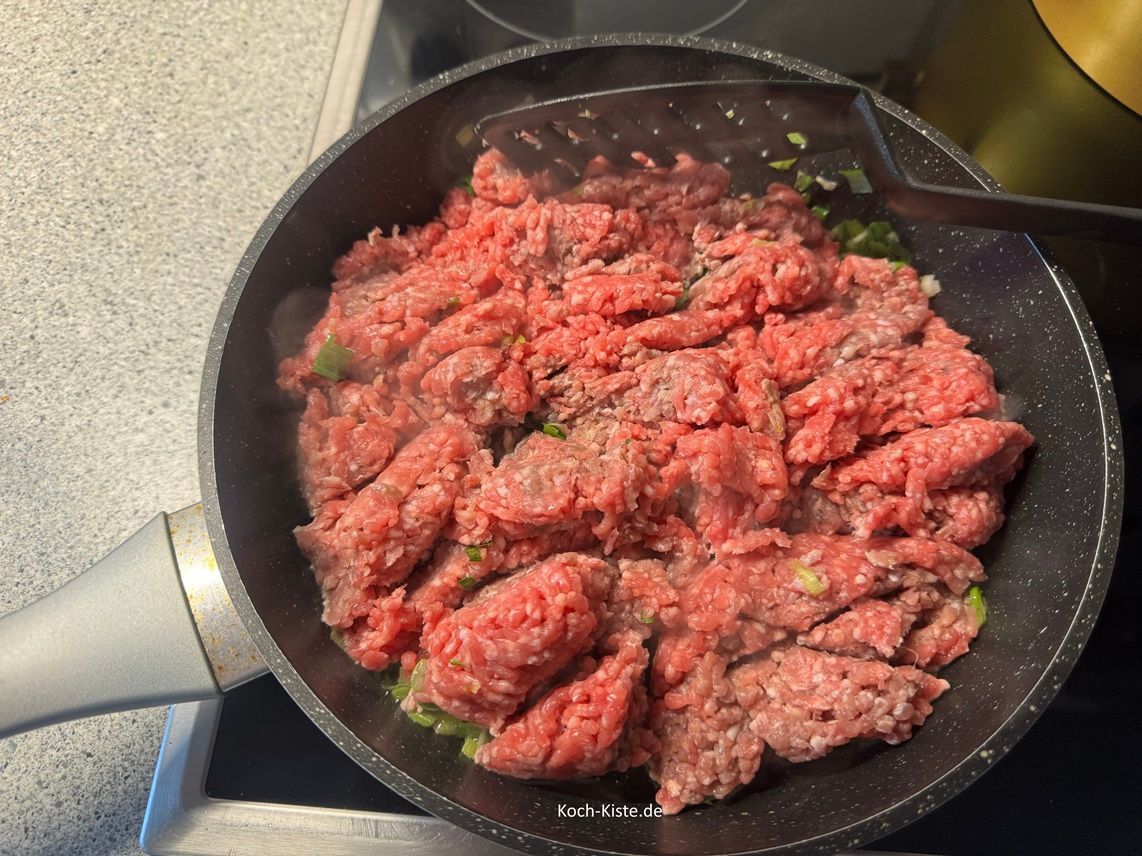 nun darf das Hackfleisch dazu und wird krümelig gebraten. Dazu hälst Du den Pfannenwender senkrecht und stichst immer wieder in die Hackfleischmasse, so dass sie sich teilt. Zwischendurch wendest Du die Hackfleischmasse.