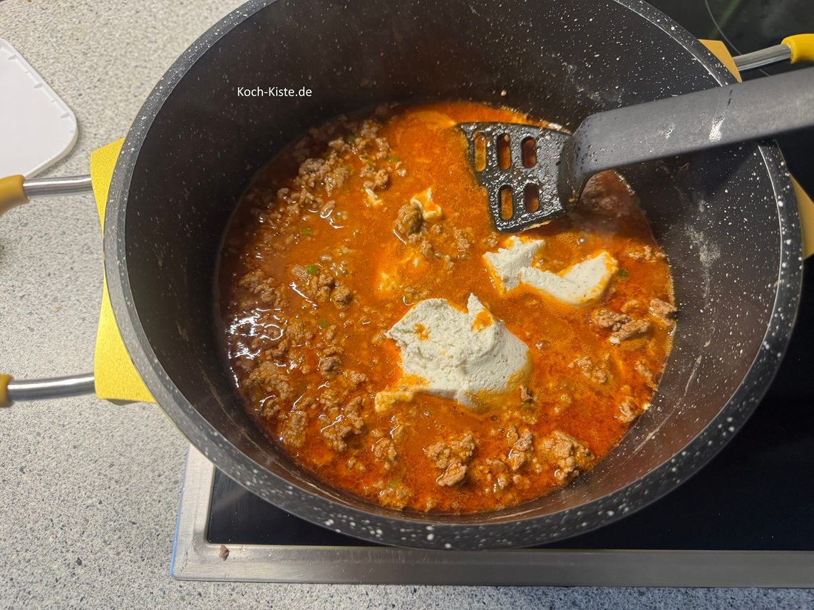 gebe die 100 g Frischkäse mit in den Topf und rühre sie gleichmäßig unter .