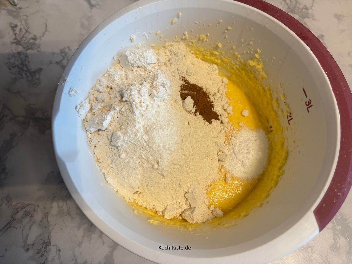 stelle die Rührschüssel wieder auf die Küchenwaage auf 0 und wiege 500 g Dinkelmehl hinein. Danach gebe 1 Packung Backpulver und 1 Teelöffel Zimt hinzu