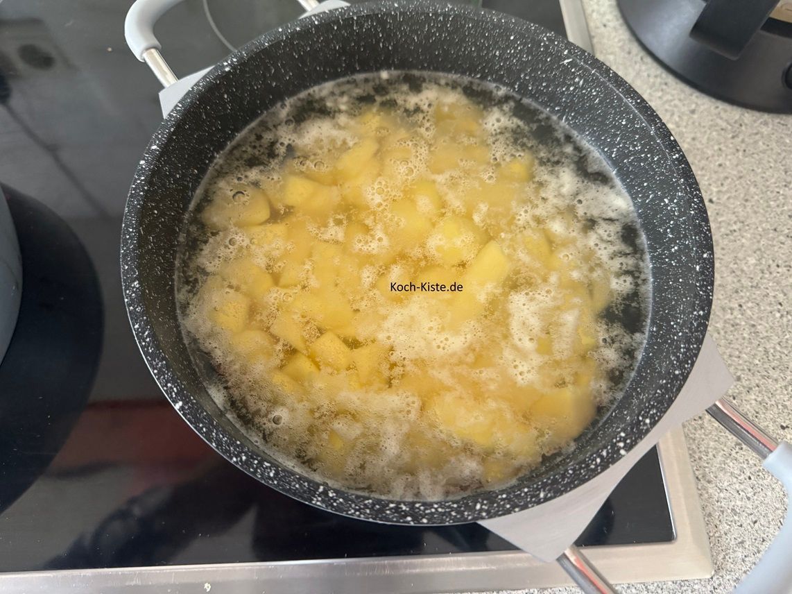 danach gebe die Kartoffelstücke in einen Topf, bringe alles zum Kochen und koche die Karotffelstücke 7 Minuten vor