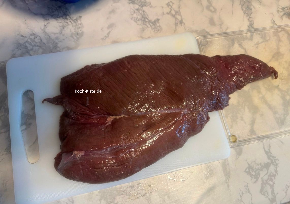 spüle den Hirschbraten unter kaltem, fließendem Wasser ab, tupfe ihn mit Küchenpapier trocken und lege ihn auf ein bzw. Schneidebrett/er - je nach Größe