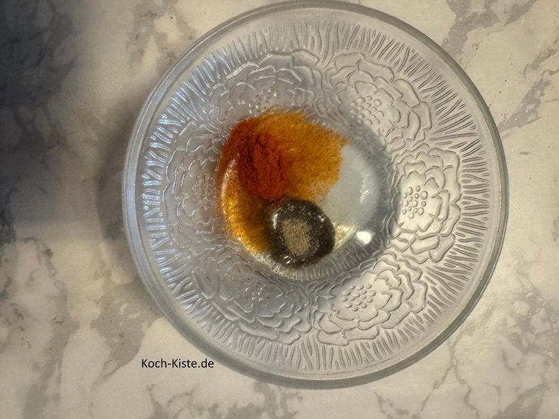 für die Marinade gebe 2 Esslöffel Sonnenblumenöl, 1 gestrichenen Teelöffel Salz, 1 gestrichenen Teelöffel Pfeffer und 1 guten Teelöffel Paprikapulver hinzu. Verrühre alles mit einem Esslöffel