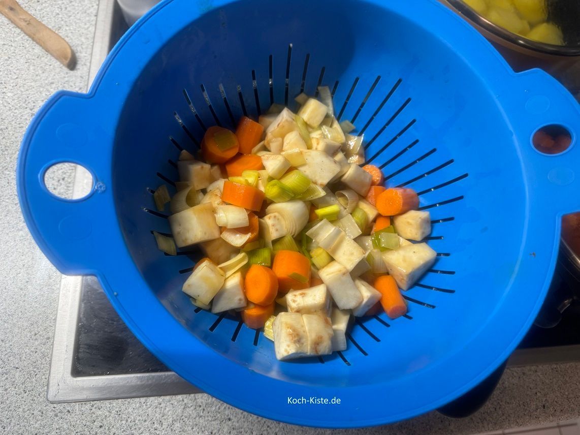 stelle einen kleinen Topf auf die Herplatte und lege das Küchensieb oben auf. Nun schütte das Gemüse und die Bratenflüssigkeit in das Küchensieb