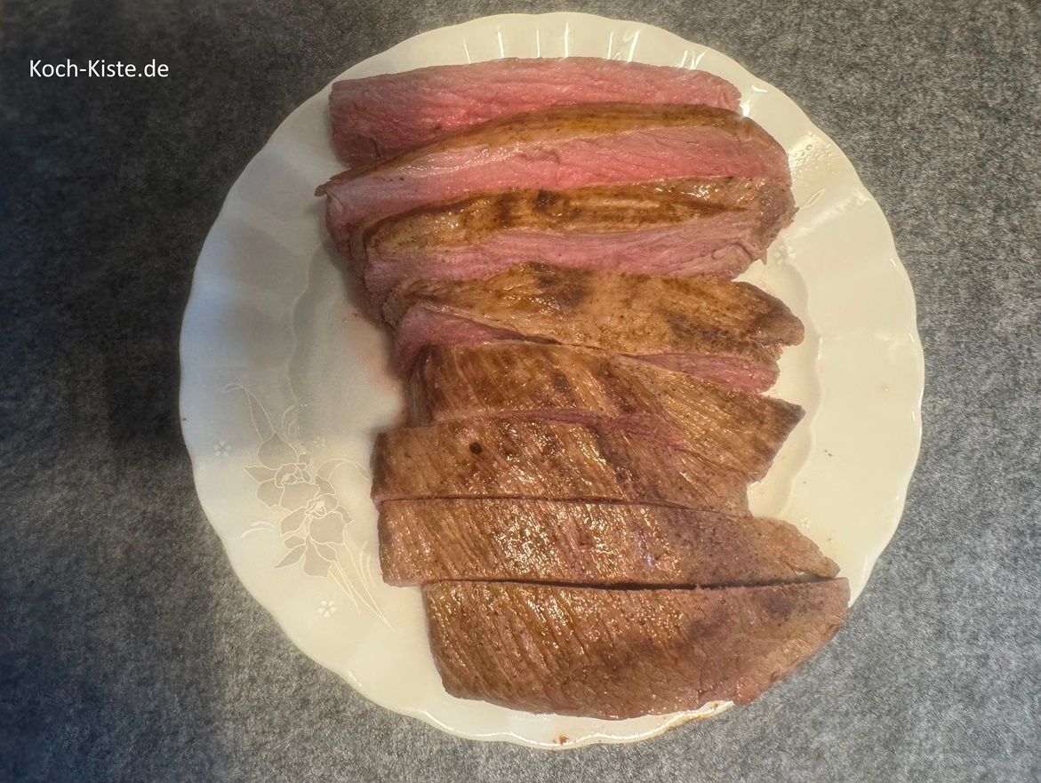 schneide den Hirschbraten mit Hilfe eines Fleischmessers und einer Fleischgabel in Scheiben.
