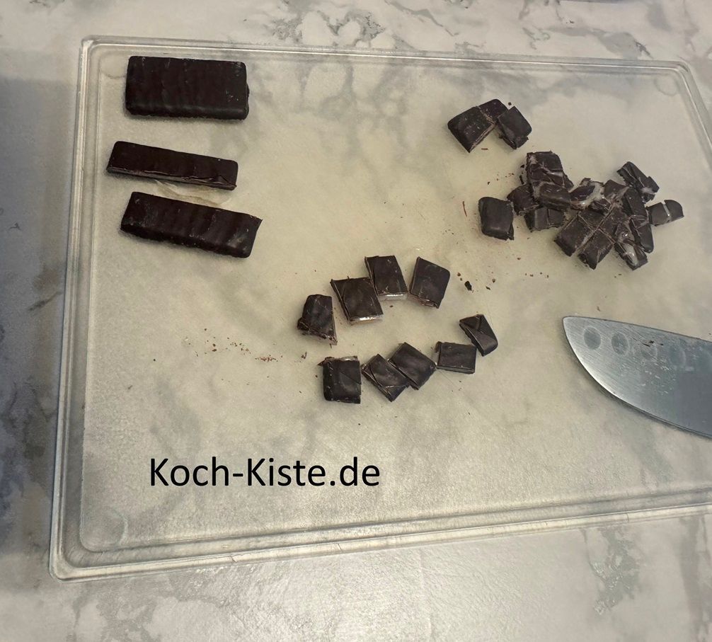 lege Dir nacheinander die Pfefferminztäfelchen auf das Schneidebrett , teile sie in 3 Streifen und schneide sie dann in kleine Stücke