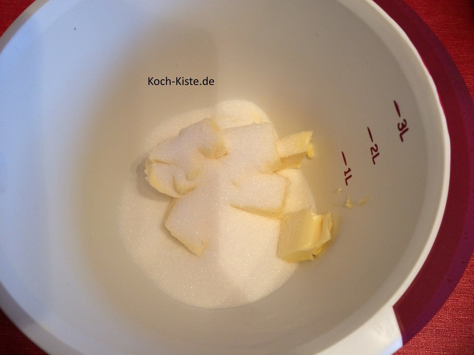 Butter und Zucker in eine Rührschüssel geben und schaumig rühren