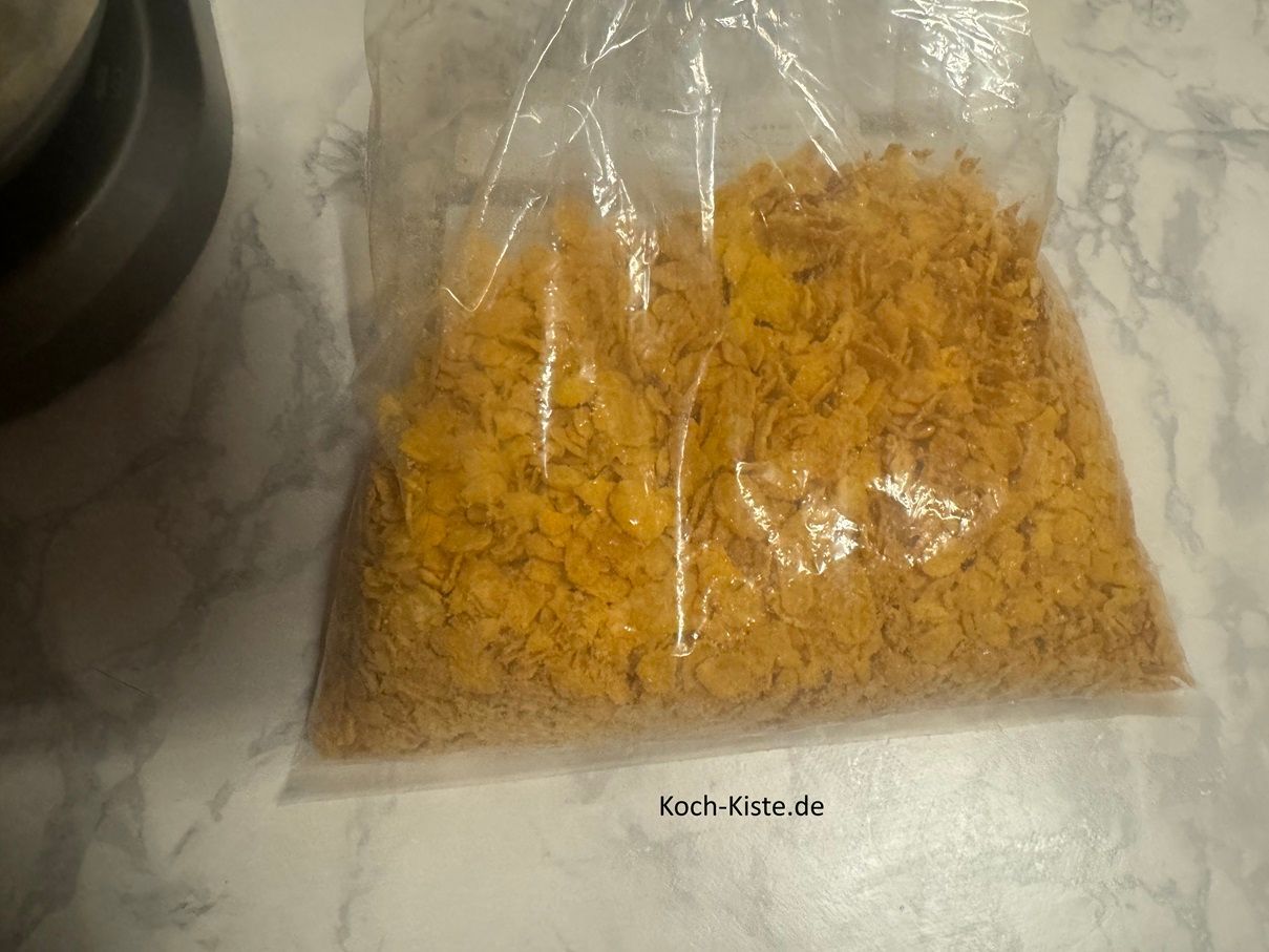 jetzt zerdrücke mit der Küchenrolle die Cornflakes oder Choco Pops in kleinere Stücke