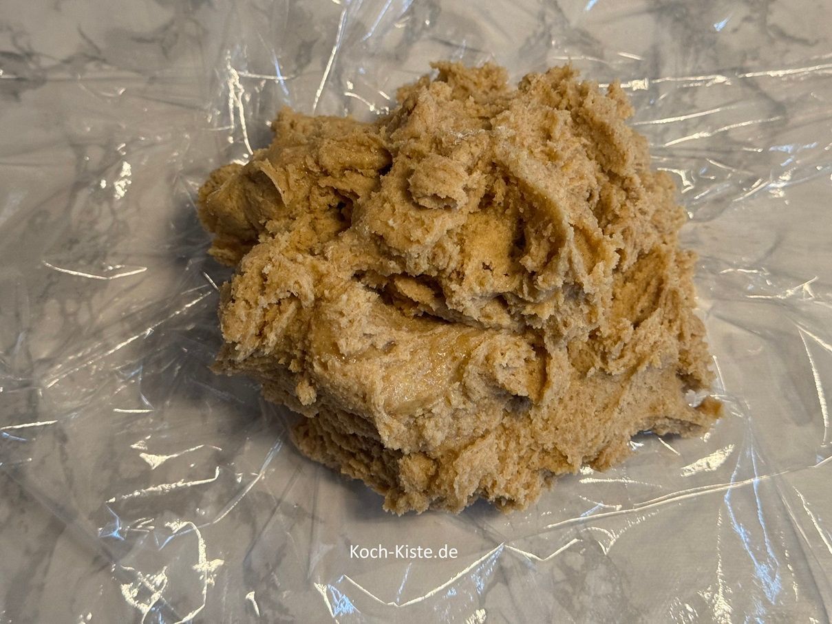 bereite Dir Klarsichtfolie vor - 2 Stücke - und gebe auf jedes Stück den halben Teig