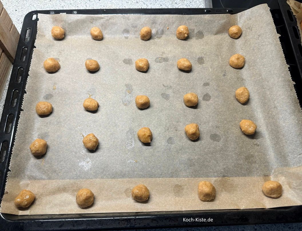 jetzt nehme 1 Teigpacket aus dem Kühlschrank. Ziehe Dir Vinyl- Einmalhandschuhe an . Dann nehme immer klene Mengen Teig und forme sie zu einer Kugel. Belege das Backblech bei 'normaler Größe' mit 25 , bei sehr kleinen Modellen mit 30 Kugeln