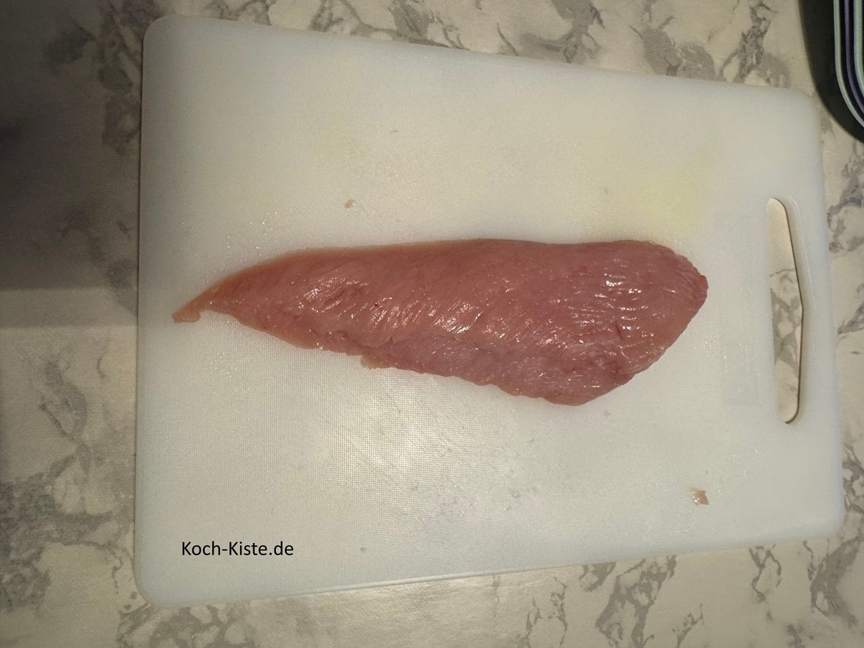 lege eine Scheibe Putenschnitzel auf das Schneidebrett