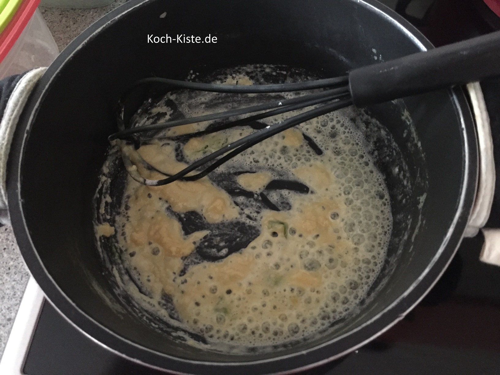 schütte ein bisschen Mehl in den Topf und verrühre es gründlich mit dem Schnebesen