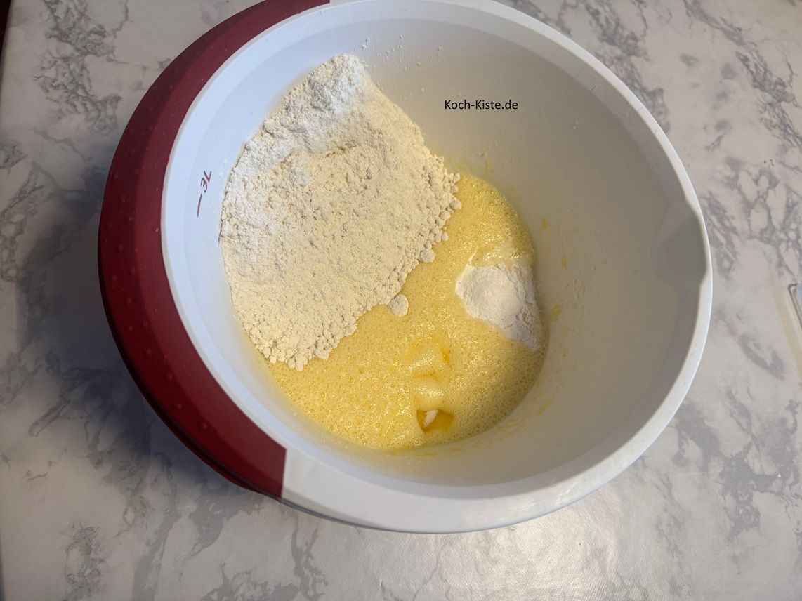 gebe in die Rührschüssel 1 Päckchen Vanillinzucker und 1 Päckchen Backpulver. Als nächstes stelle die Rührschüssel wieder auf die Küchenwaage auf 0 und wiege 250 g Dinkelmehl ab