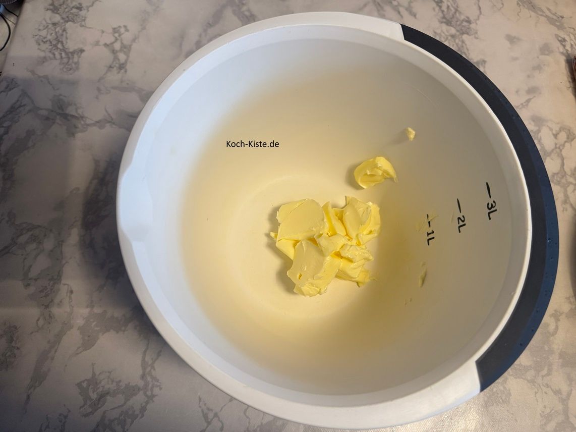 als nächstes stelle die Rührschüssel auf die Küchenwaage und schubse mit einem Messer 100 g weiche Butter hinein