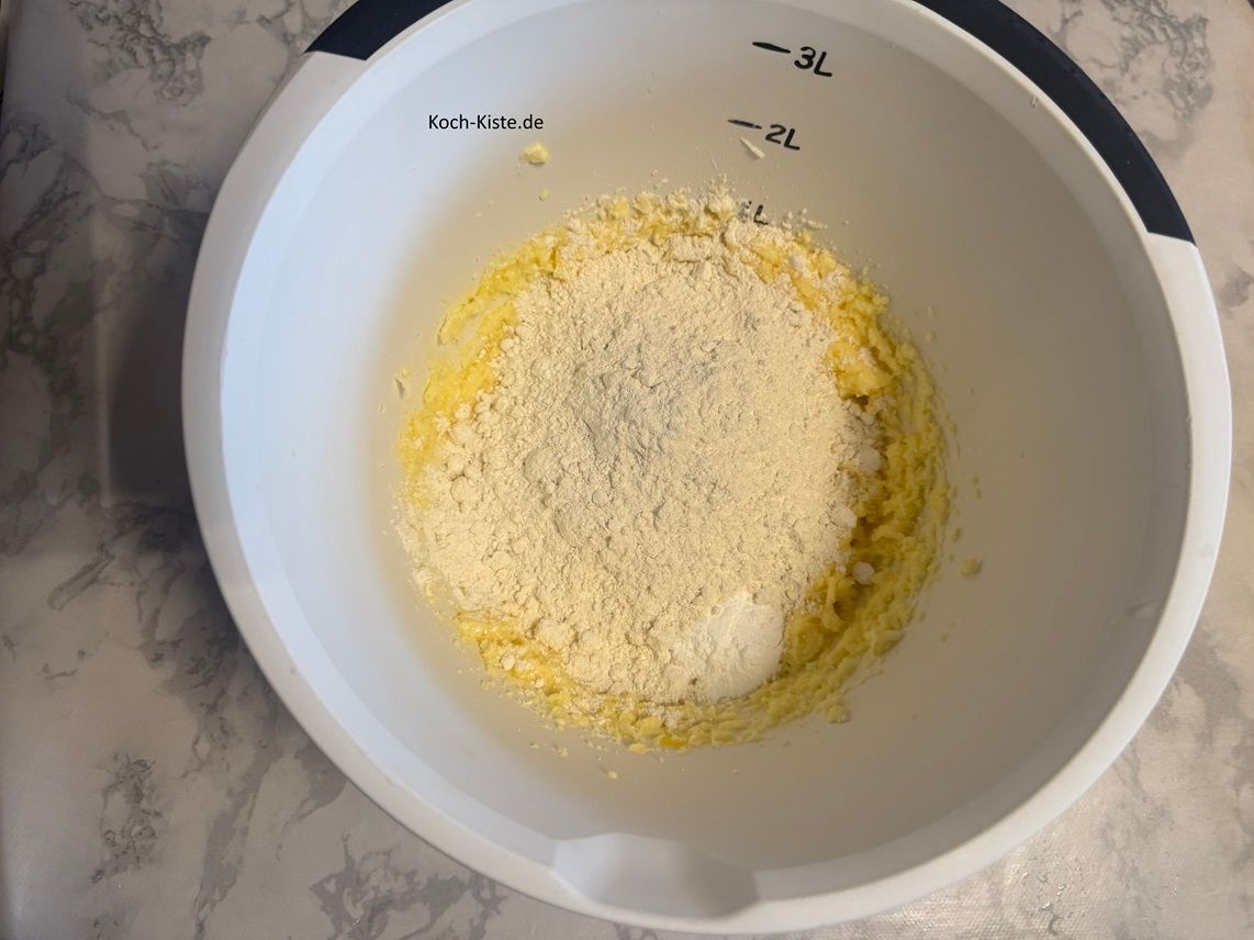 stelle die Rührschüssel wieder auf die Küchenwaage und wiege 180 g Dinkelmehl hinzu. Dann kommt 1 Teelöffel Backpulver hinzu