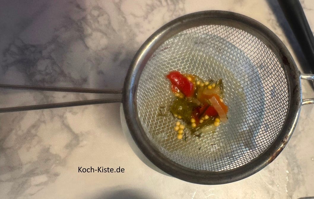 nun gebe 8 Esslöffel Gurkenwasser in das Sieb, so dass es in das Mayonaiseglas läuft. Schließe den Deckel, schüttel kräftig und gieße das Gurken-Mayo Wasser mit in die Rührschüssel