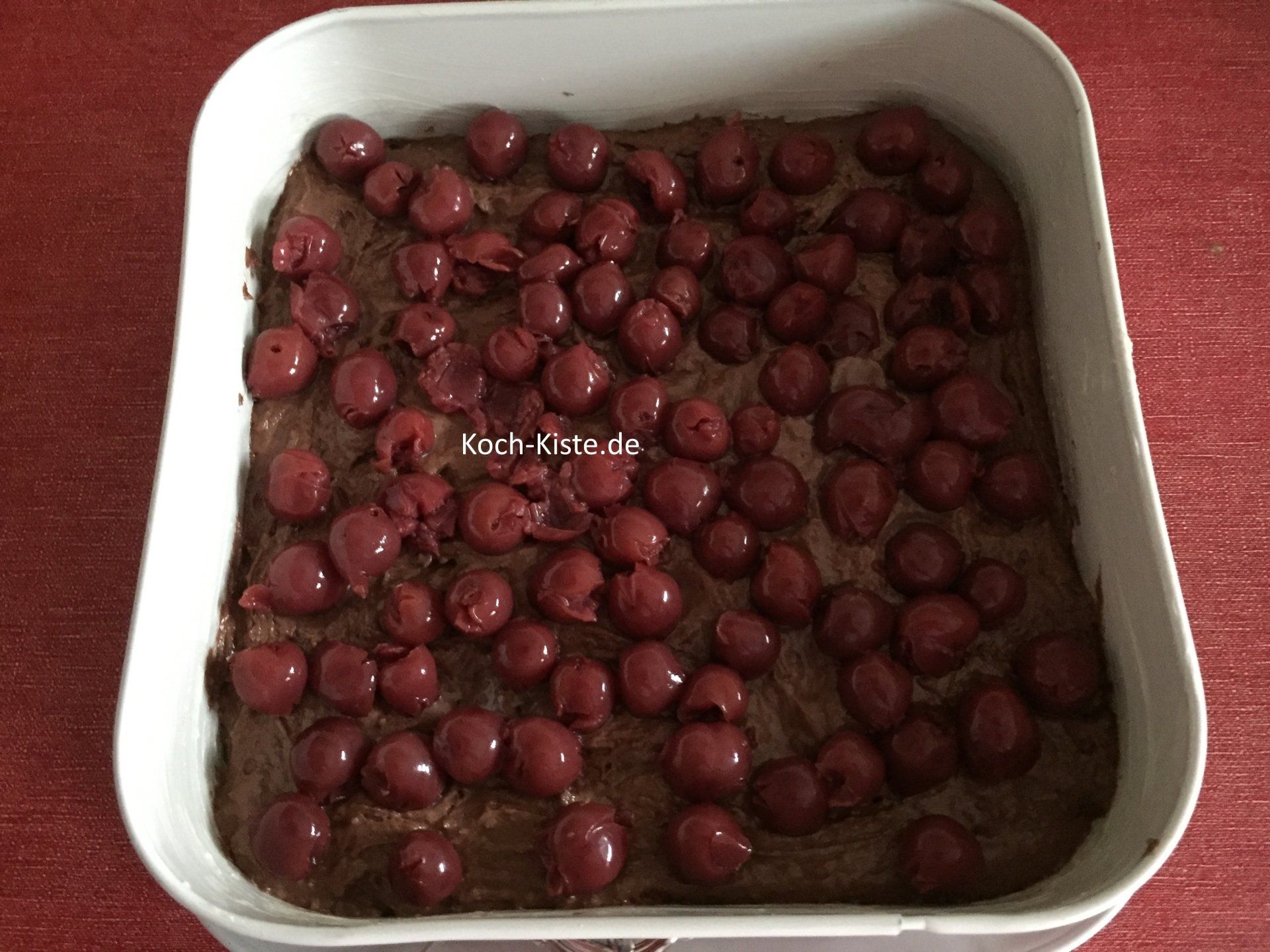 Kirschen auf den Tortenteig gleichmäßig verteilen