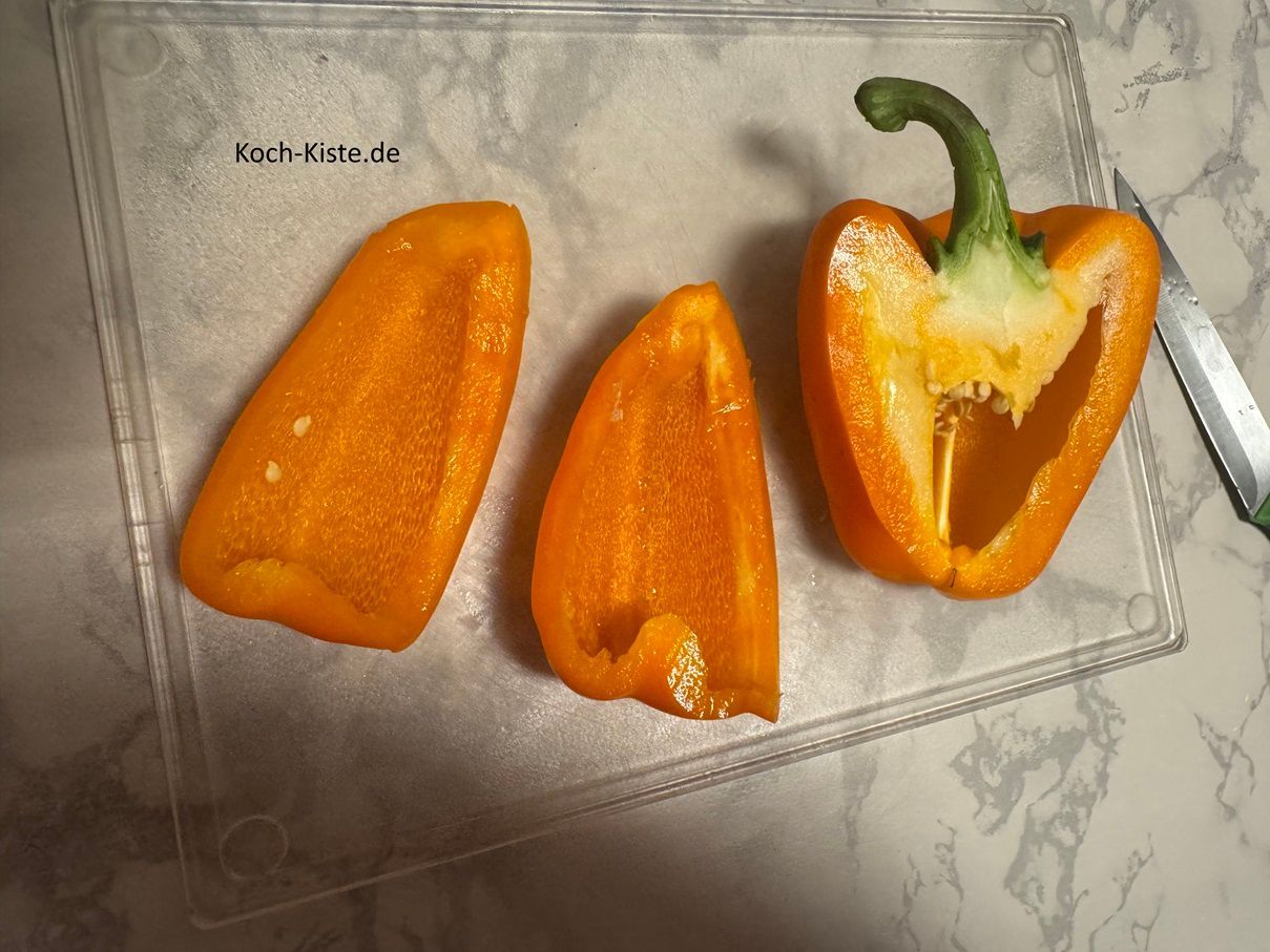 dann entferne den Strunk und viertel die Paprikahälfte. Wiederhole das auch bei der anderen Paprikahälfte.
