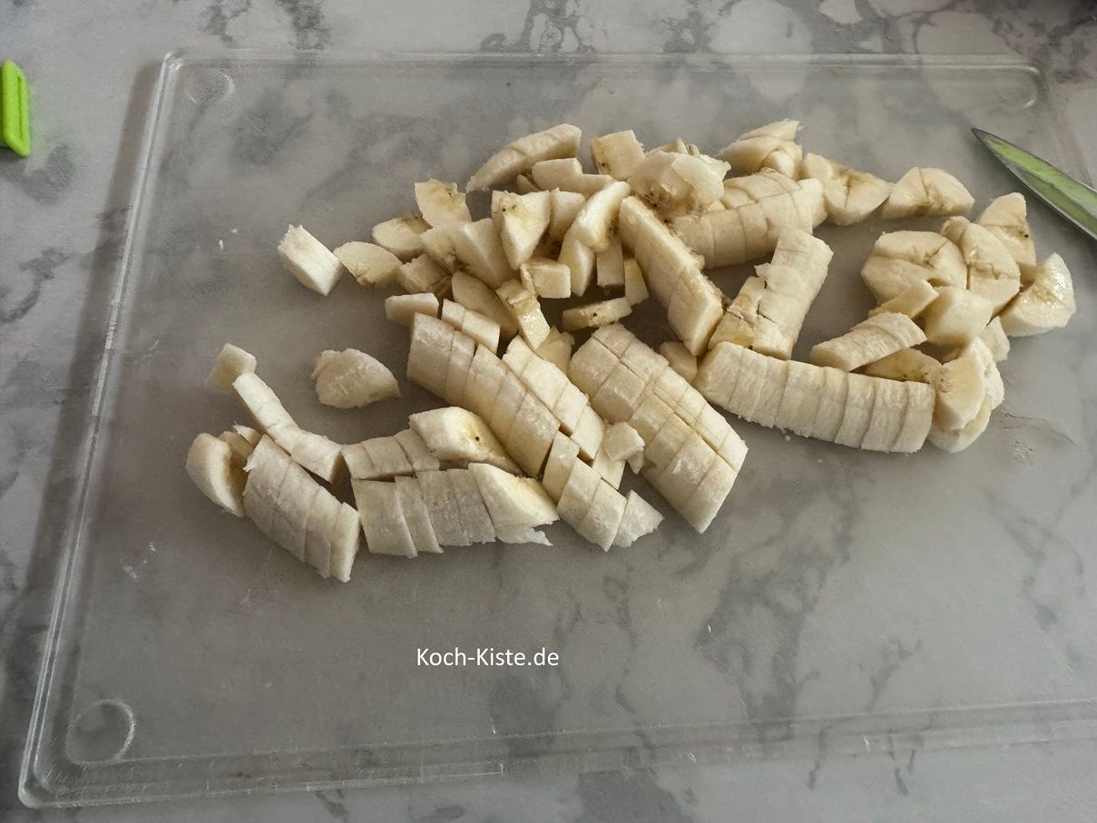 wiederholde die Schritte bis beide Bananen in kleine Stücke geschnitten sind. Gebe die Bananenstücke in eine kleine Schüssel