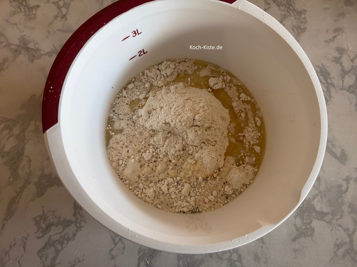 jetzt darf die Hefemilch mit in die Rühschüssel . Außerdem kommt die Prise Salz hinzu.