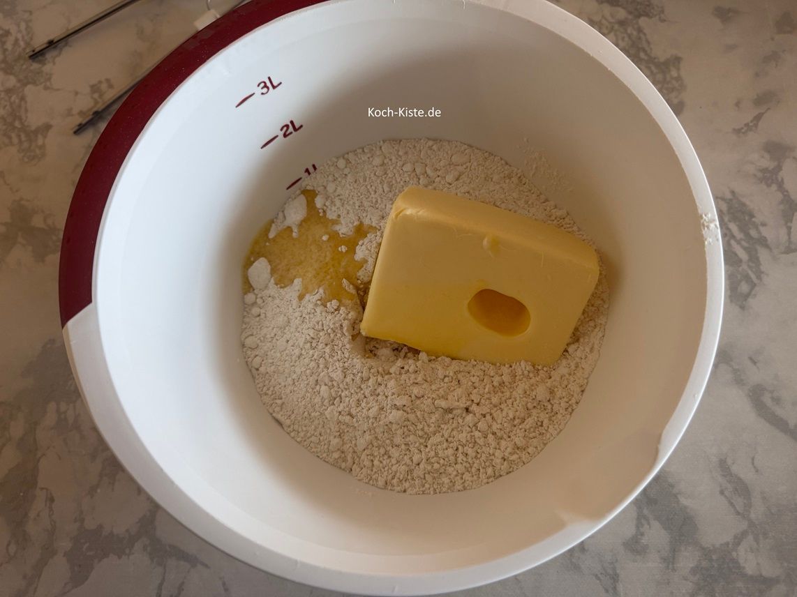 schubse mit Hilfe des Teigspatels die Butter mit in die Rührschüssel