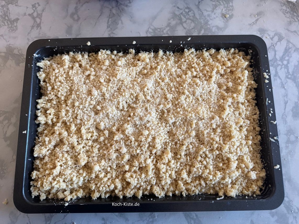 dann verteile die Streusel gleichmäßig auf dem Teig.