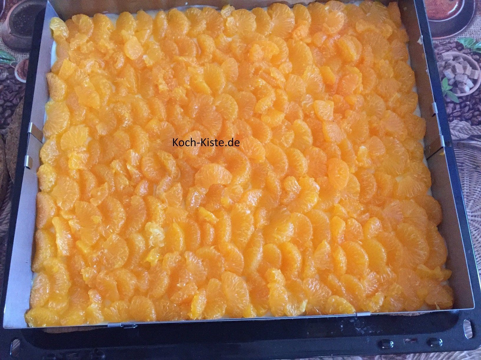 beldege den Kuchen mit Mandarinen, ordne sie dachziegelmäßig an