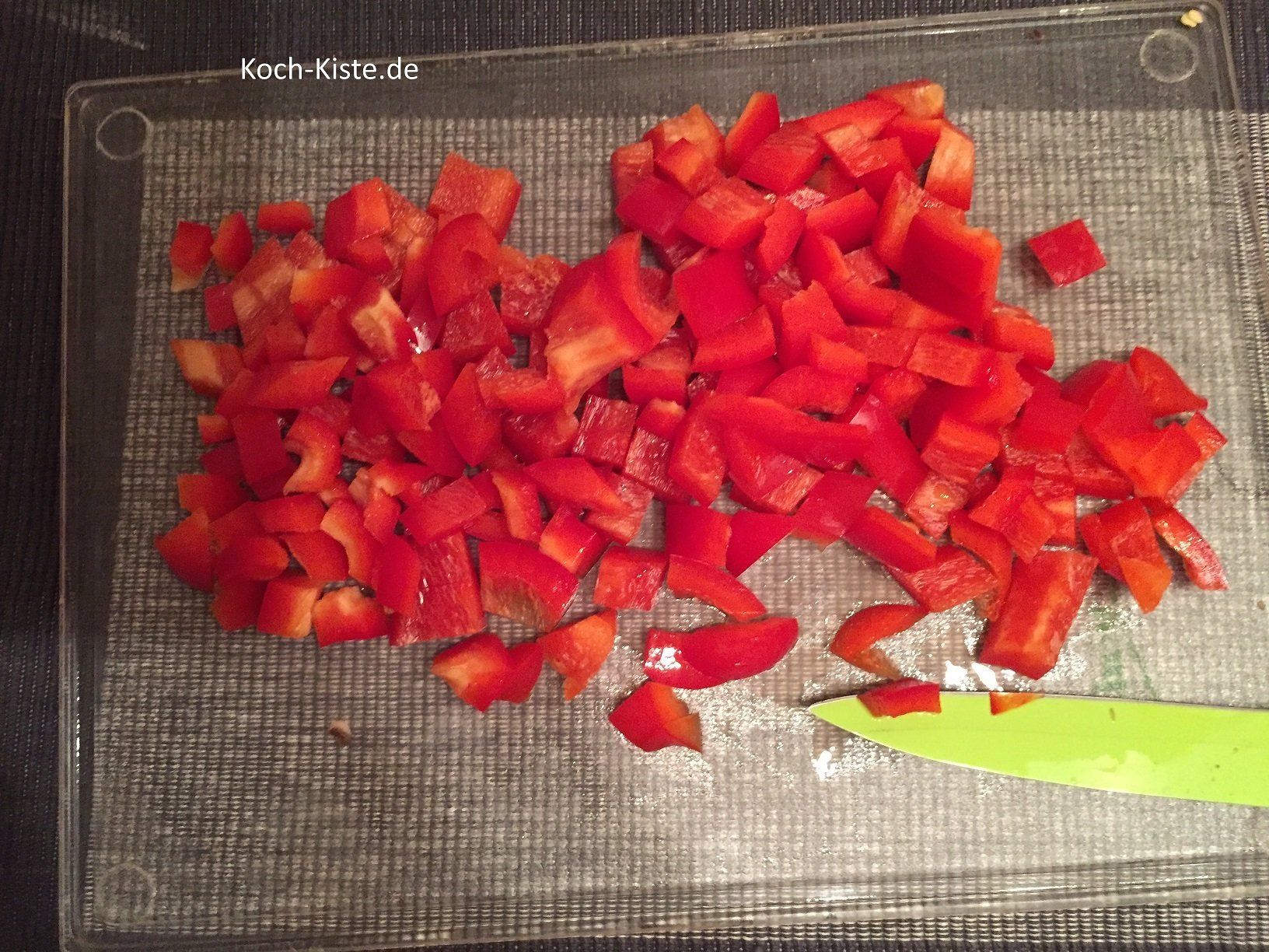Paprika halbieren, enthäuten, entkernen und in kleine Stücke schneiden