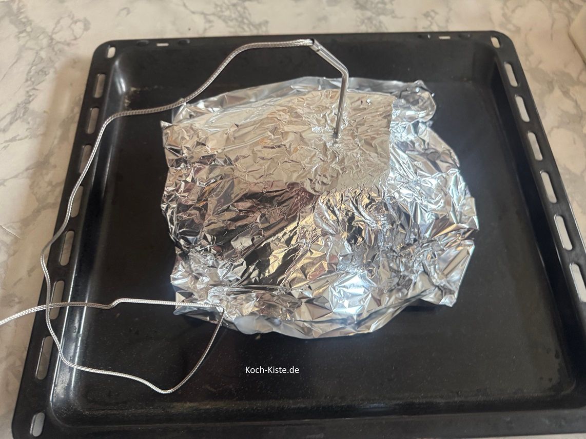 jetzt stecke das digitale Fleischthermometer in das Fleisch, schiebe das Backblech auf die mittlere Schiene des Backofens und bringe das Thermometer außen an der Backofentür / oder Schaltfläche vom Herd an .