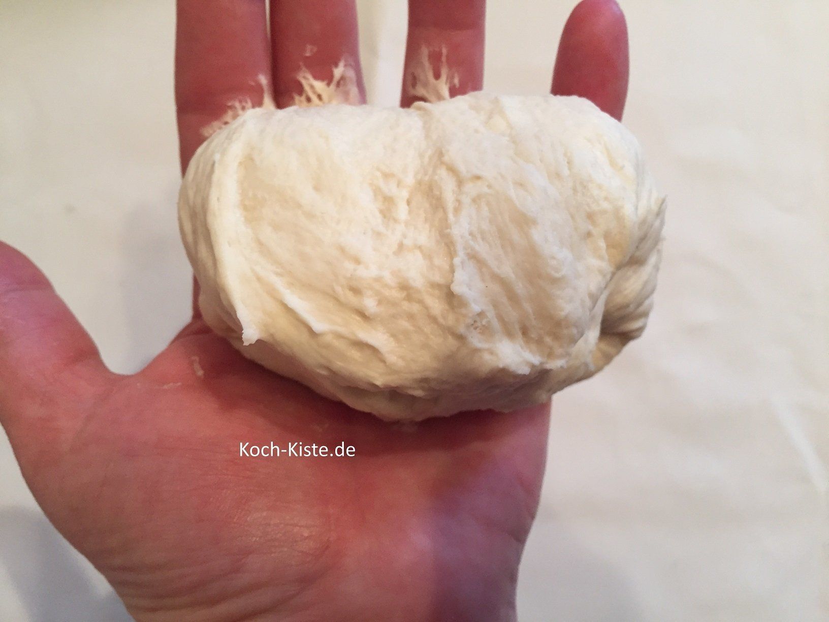 Jetzt den Teig nach oben ziehen und auf die untere Teigkante legen. Auch diesen Vorgang öfter wiederholen.