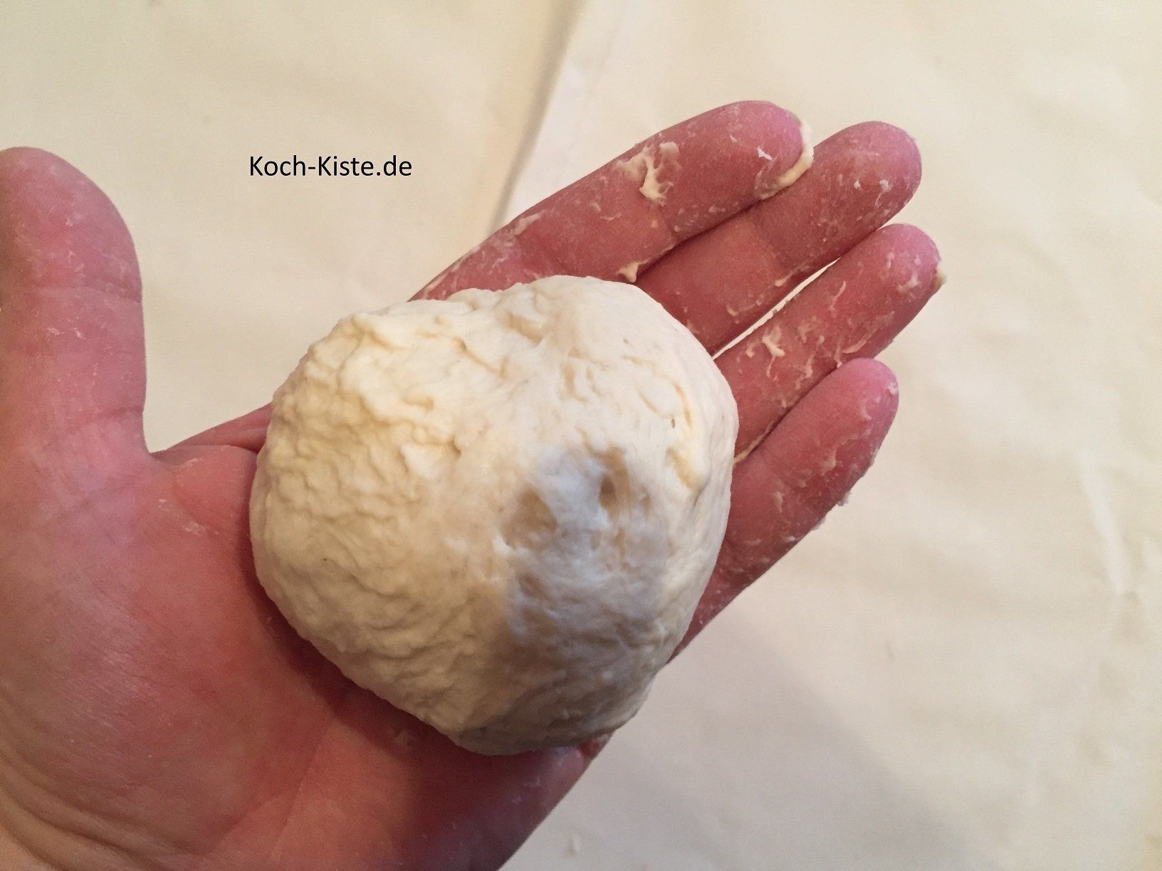 Teigstück schleifen, das bedeutet duch drehende Bewegungen ein Brötchen formen.